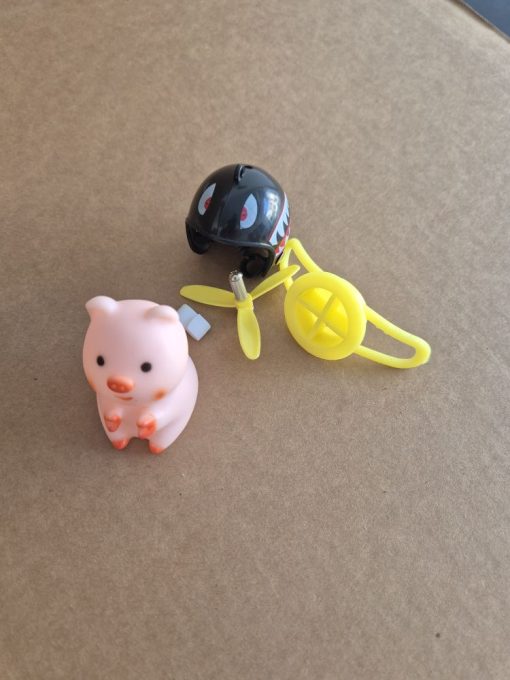 Pinky pig / duck as a decoration on the steering wheel of the scooter with propeller and helmet